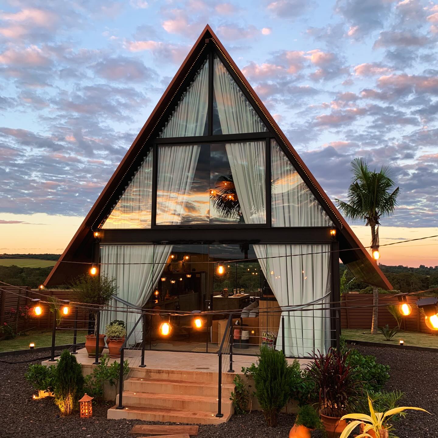 Fachada triangular do Refúgio Talu iluminada ao entardecer